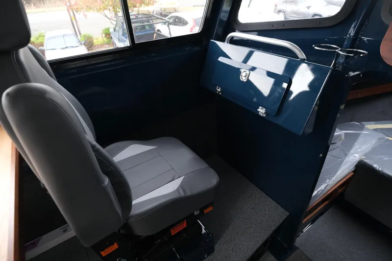 Slide: The Image of Interior of 2026 Hewescraft 250 Pacific Explorer, featuring a comfortable seat and storage compartment. - 16