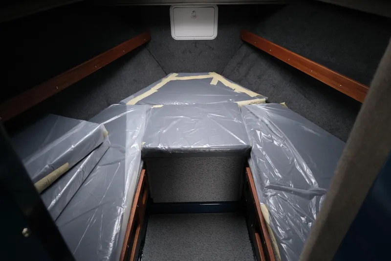 Slide: The Image of 2026 Hewescraft 250 Pacific Explorer cabin interior with plastic-covered cushions. - 17