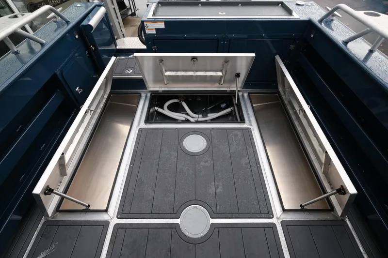 Slide: The Image of 2026 Hewescraft 250 Pacific Explorer deck with open storage compartments. - 19