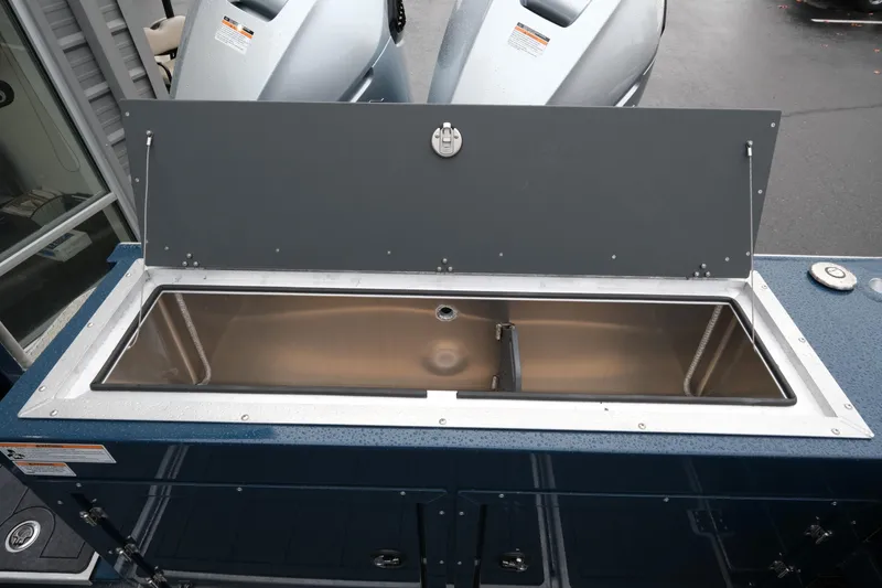 Slide: The Image of 2026 Hewescraft 250 Pacific Explorer livewell, open lid, stainless steel interior, outdoor setting. - 20