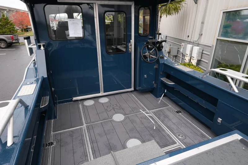 Slide: The Image of 2026 Hewescraft 250 Pacific Explorer boat interior with steering wheel and spacious deck. - 7