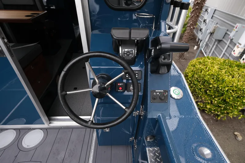 Slide: The Image of 2026 Hewescraft 250 Pacific Explorer helm with steering wheel and controls. - 9