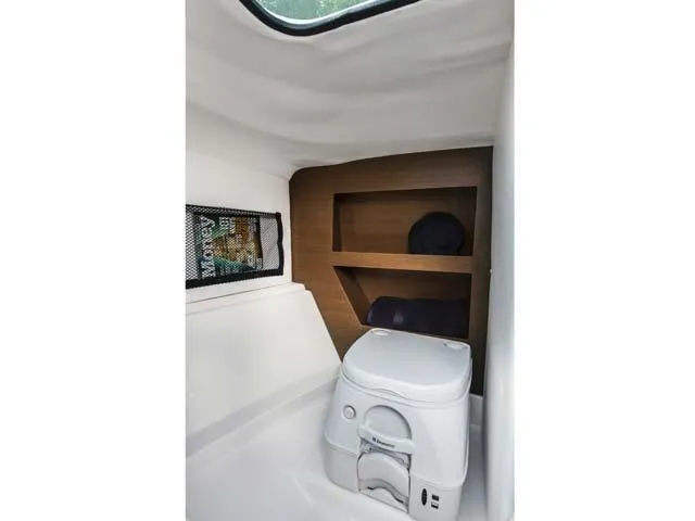 Slide: The Image of Manufacturer Provided Image: 2015 Sea Ray 220 Sundeck Outboard cabin with portable toilet and storage shelves. - 11
