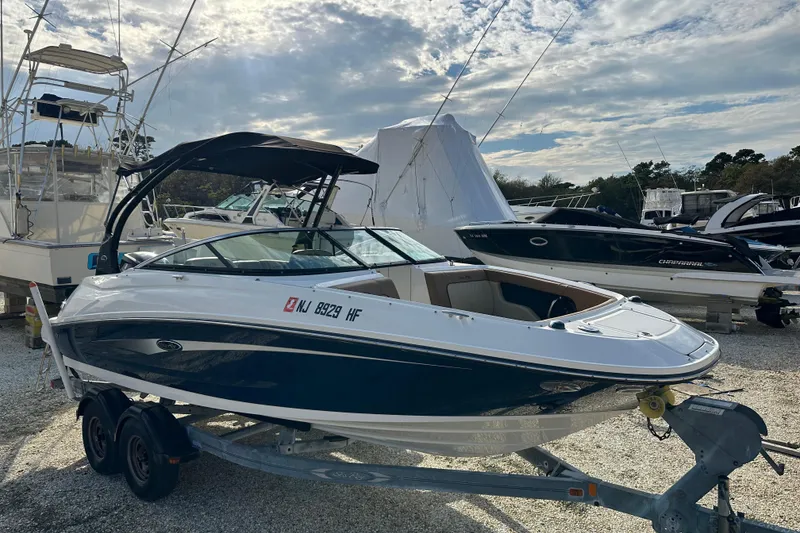 Slide: The Image of 2015 Sea Ray 220 Sundeck Outboard boat on trailer, parked in marina. - 14