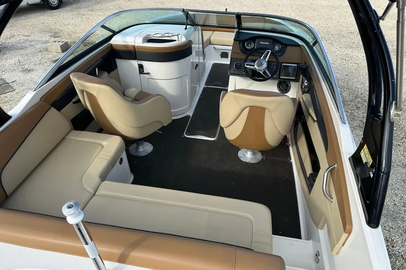 Slide: The Image of 2015 Sea Ray 220 Sundeck Outboard interior with beige seating and modern dashboard. - 17