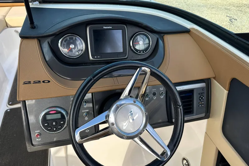 Slide: The Image of 2015 Sea Ray 220 Sundeck Outboard dashboard with steering wheel and gauges. - 18