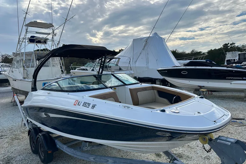 Slide: The Image of 2015 Sea Ray 220 Sundeck Outboard boat on trailer, parked in marina. - 27