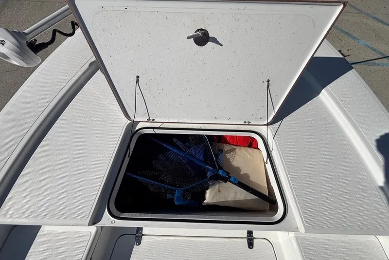 Slide: The Image of Open storage compartment on 2013 BlackJack 224 boat, containing fishing gear and equipment. - 10