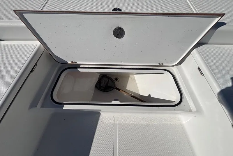 Slide: The Image of Open storage compartment on 2013 BlackJack 224 boat deck with a net inside. - 13