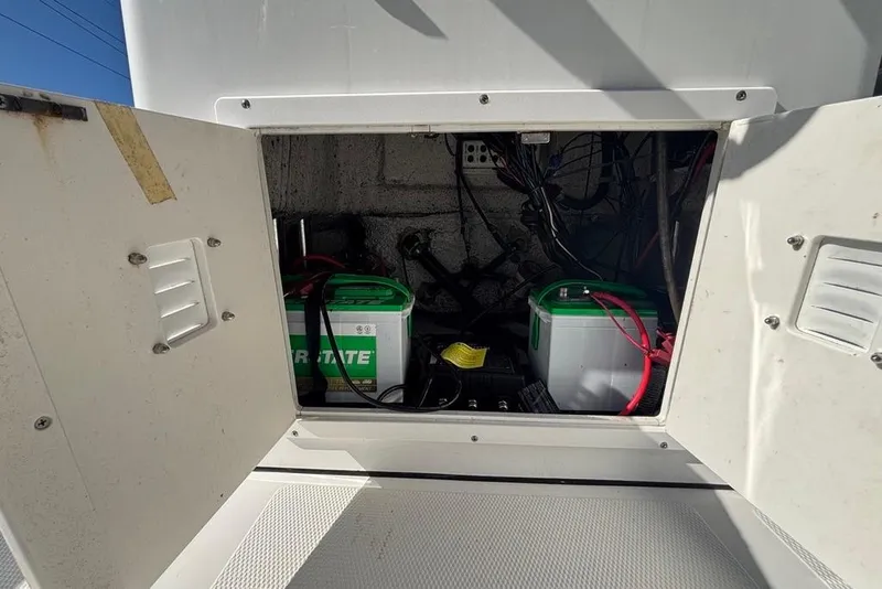 Slide: The Image of Open compartment of a 2013 BlackJack 224 boat showing batteries and wiring. - 18