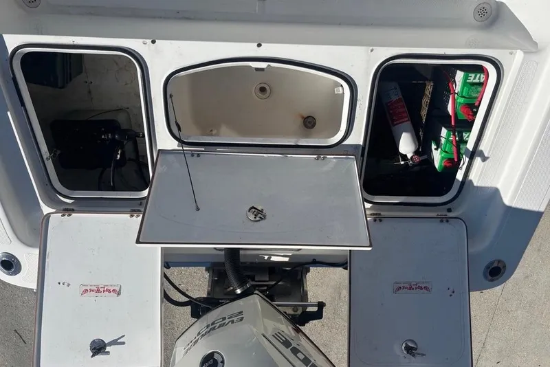 Slide: The Image of Open compartments on a 2013 BlackJack 224 boat, showing storage and equipment. - 20