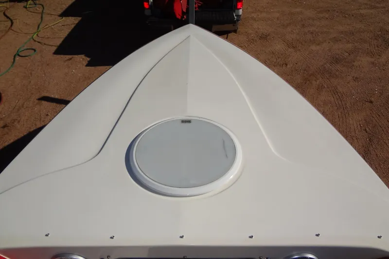 Slide: The Image of 2003 Ski Centurion Tsunami boat bow with circular hatch, parked on sandy ground. - 10