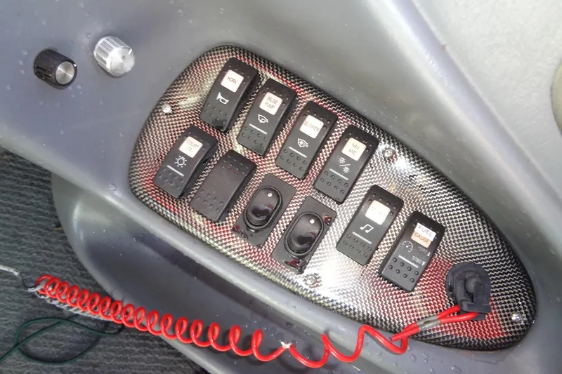 Slide: The Image of Control panel of a 2003 Ski Centurion Tsunami boat with various switches and buttons. - 20