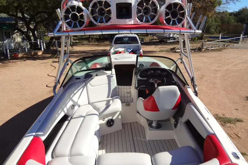 Slide: The Image of 2003 Ski Centurion Tsunami boat interior with red and white seating, speakers, and steering wheel. - 27