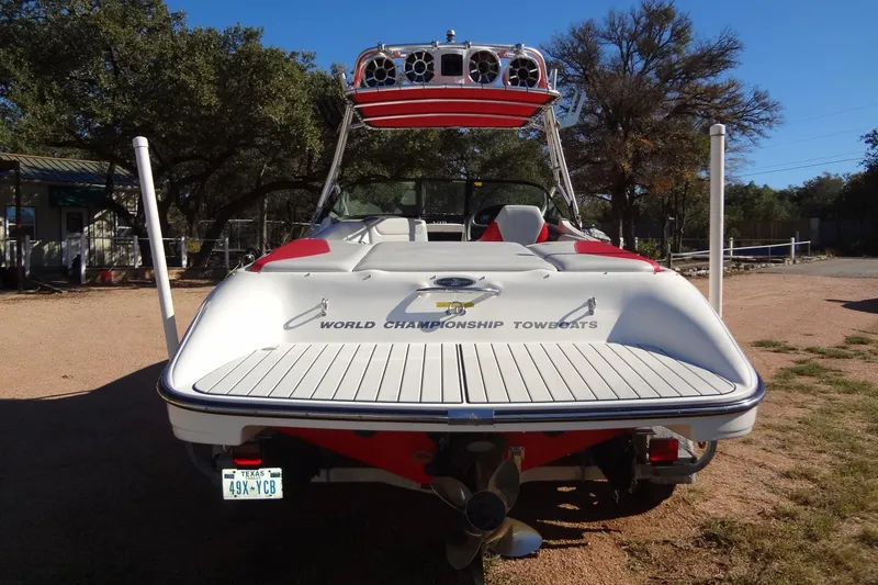 Slide: The Image of 2003 Ski Centurion Tsunami boat, rear view, on a sunny day with trees in the background. - 3