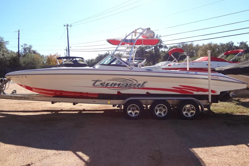 Slide: The Image of 2003 Ski Centurion Tsunami boat on trailer, white with red accents, parked outdoors. - 6