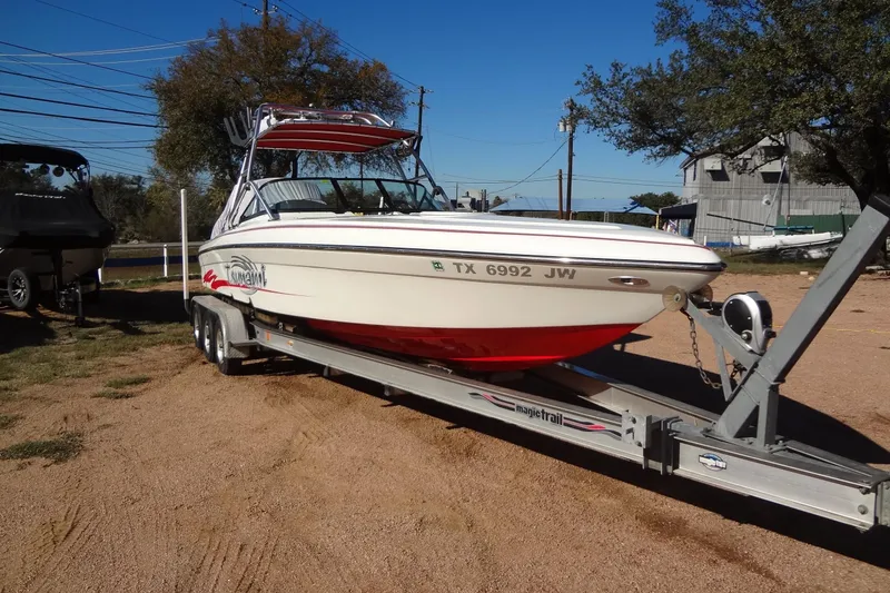 Slide: The Image of 2003 Ski Centurion Tsunami boat on trailer, parked outdoors on a sunny day. - 8