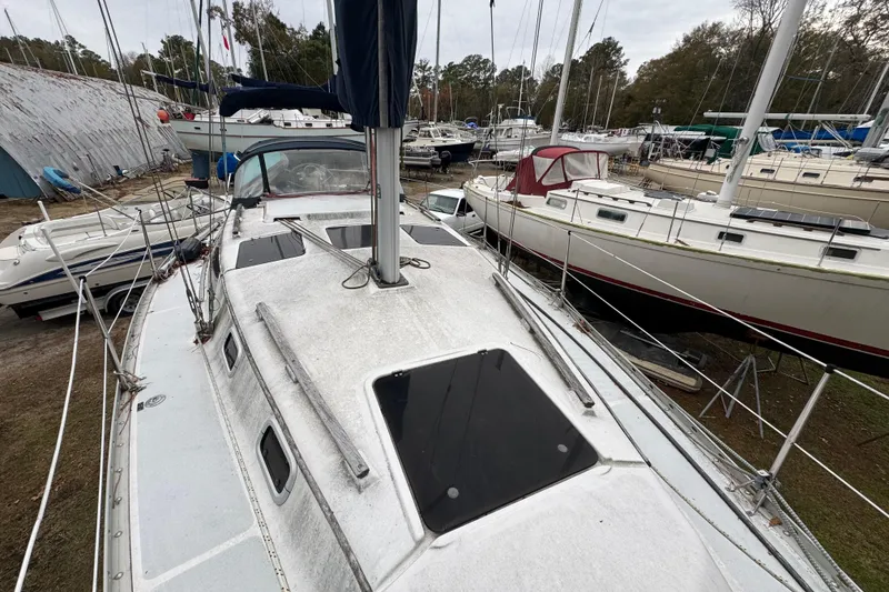 Slide: The Image of 1992 Hunter 33.5 sailboat on land, surrounded by other boats in a marina. - 13