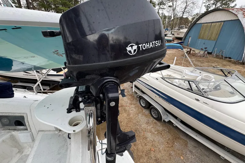 Slide: The Image of Tohatsu outboard motor on a 1992 Hunter 33.5 sailboat, docked near other boats. - 21