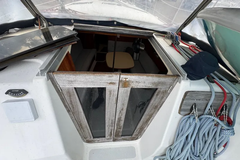 Slide: The Image of 1992 Hunter 33.5 sailboat cockpit with open hatch, ropes, and interior view. - 24