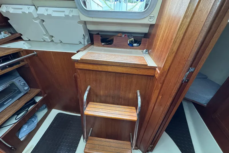 Slide: The Image of Interior of a 1992 Hunter 33.5 sailboat with wooden steps and storage. - 39