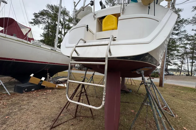 Slide: The Image of 1992 Hunter 33.5 sailboat on stands, ladder attached, in a boatyard setting. - 5