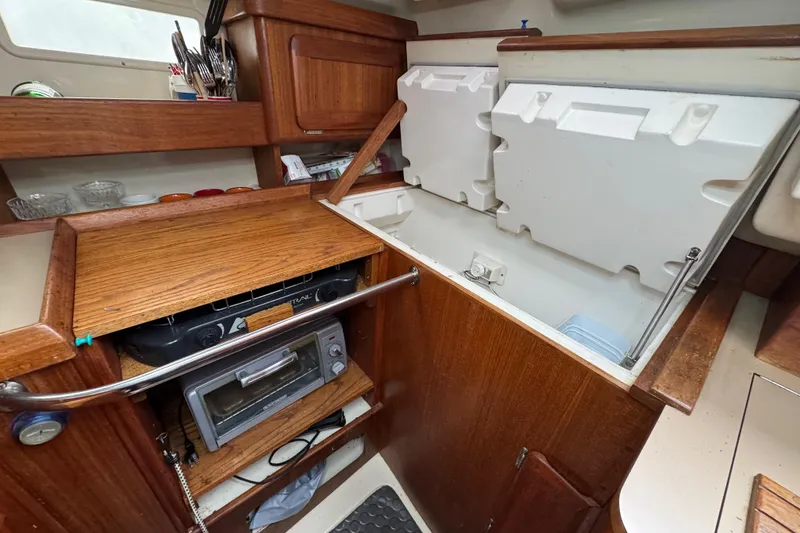Slide: The Image of Interior of 1992 Hunter 33.5 sailboat kitchen with wooden cabinetry and appliances. - 53