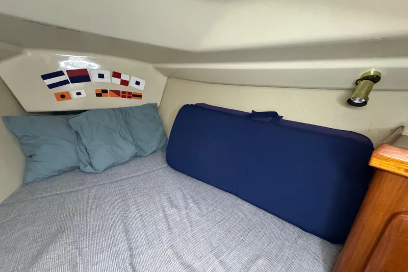 Slide: The Image of Cozy cabin interior of 1992 Hunter 33.5 sailboat with nautical flags and bedding. - 68