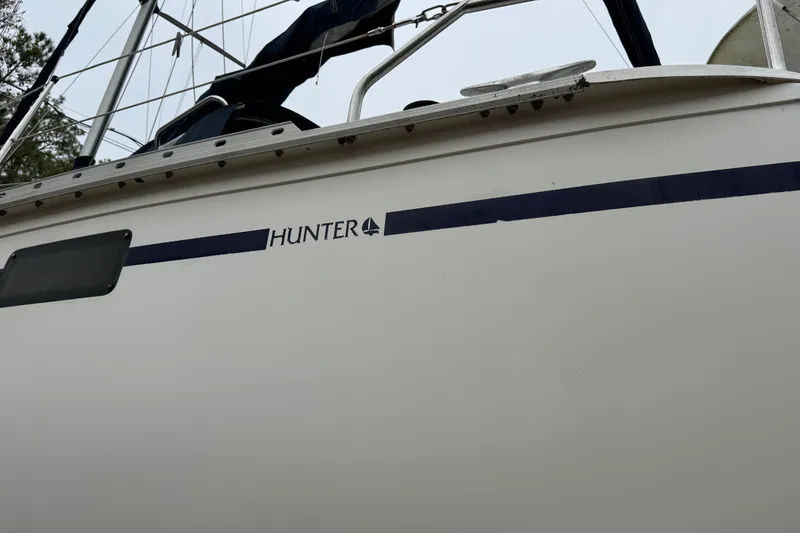 Slide: The Image of 1992 Hunter 33.5 sailboat side view with logo and railing. - 7