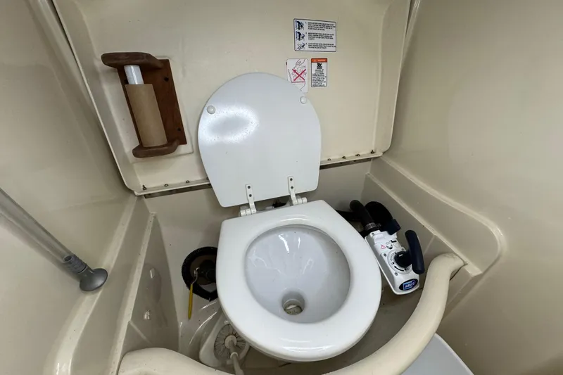 Slide: The Image of 1992 Hunter 33.5 boat bathroom with marine toilet and paper holder. - 79