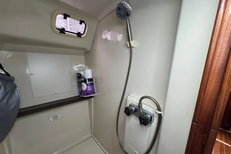 Slide: The Image of Shower area in 1992 Hunter 33.5 sailboat with handheld showerhead and storage shelf. - 84