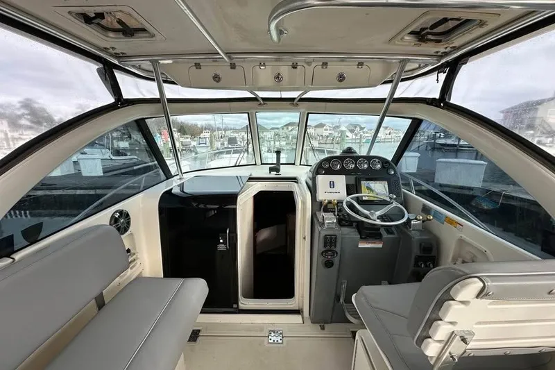 Slide: The Image of 2004 Pursuit 3100 Offshore boat interior with helm, seating, and navigation equipment. - 2