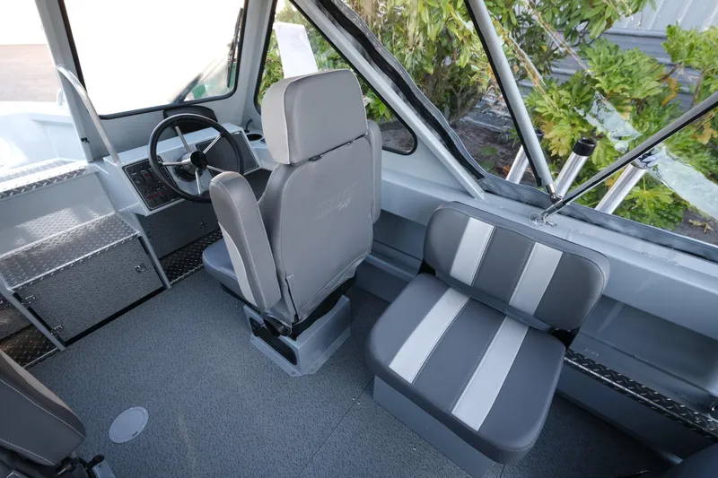 Slide: The Image of Interior of 2025 Hewescraft 190 SeaRunner ET boat, featuring steering wheel and seating. - 9