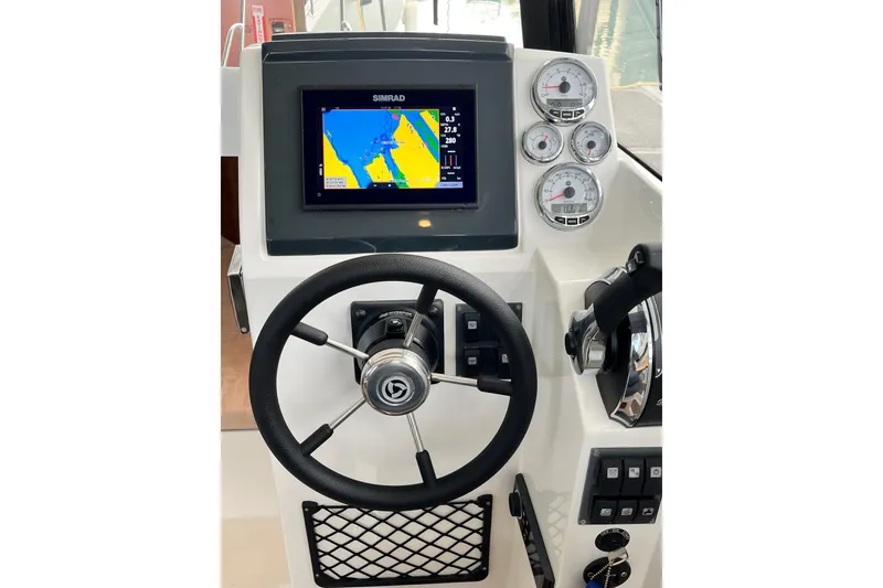 Slide: The Image of 2023 Parker Poland Skamander boat dashboard with steering wheel and navigation display. - 20