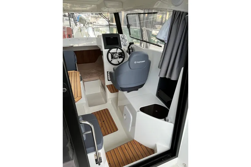 Slide: The Image of 2023 Parker Poland Skamander boat interior with steering wheel and seating area. - 21