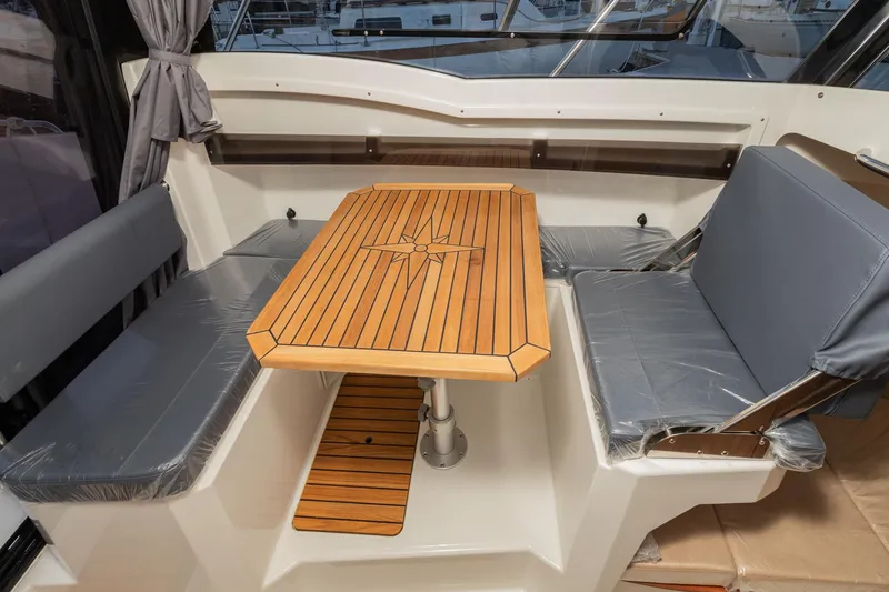 Slide: The Image of 2023 Parker Poland Skamander boat interior with wooden table and cushioned seating. - 9