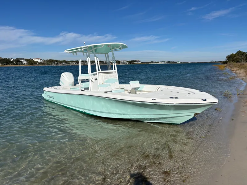 Slide: The Image of 2018 Robalo 246 Cayman boat parked by the shore. - 2