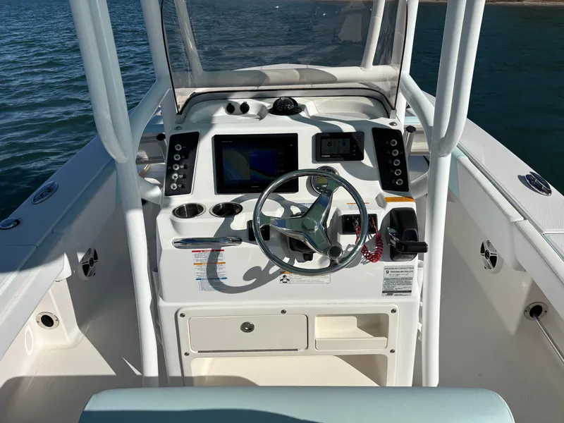 Slide: The Image of Helm console of a 2018 Robalo 246 Cayman boat on water. - 27