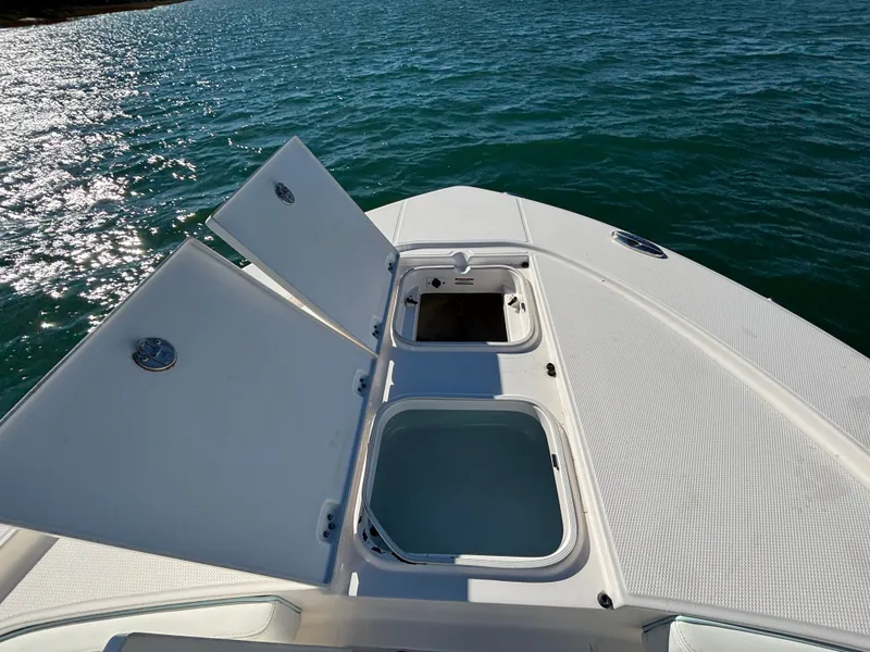 Slide: The Image of 2018 Robalo 246 Cayman with open storage compartments on water. - 47
