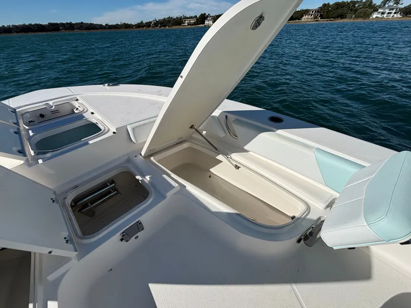 Slide: The Image of 2018 Robalo 246 Cayman with open storage compartments on the water. - 49