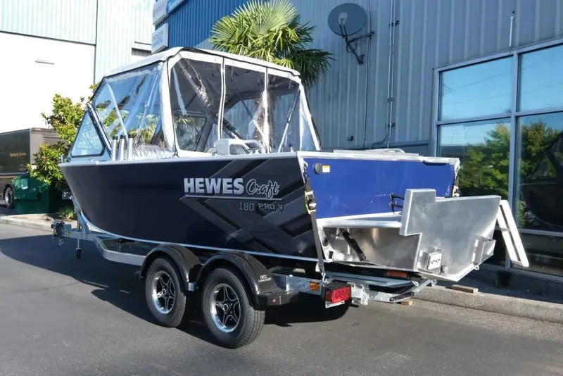 Slide: The Image of 2026 Hewescraft 180 Pro-V ET boat on trailer, parked outside industrial building. - 4