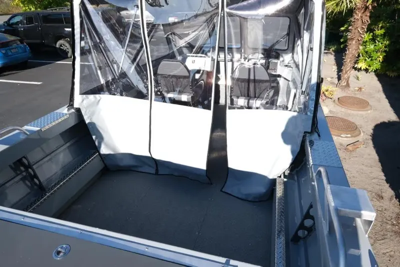 Slide: The Image of 2026 Hewescraft 180 Pro-V ET boat interior with protective cover in parking lot. - 7