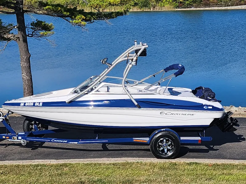 The Image of 2012 Crownline 195 SS boat on trailer by a lake, featuring sleek design and blue accents. - 0