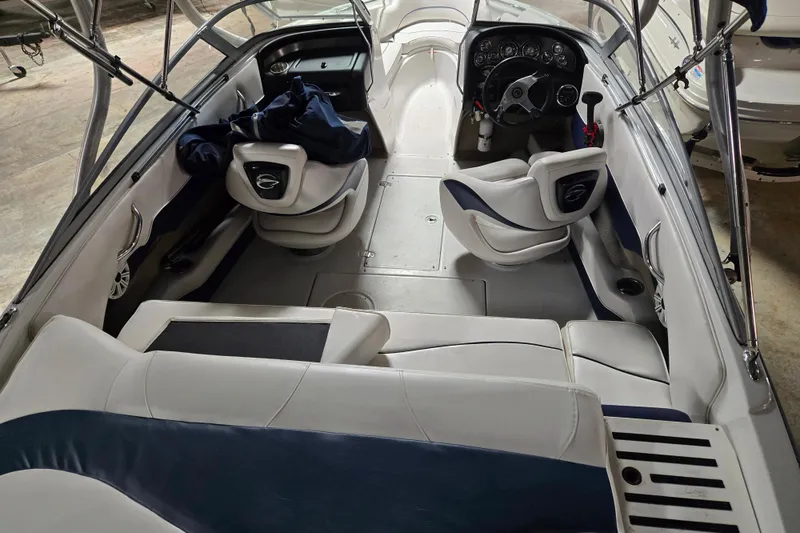 Slide: The Image of 2012 Crownline 195 SS boat interior with white and blue seating, steering wheel, and dashboard. - 23