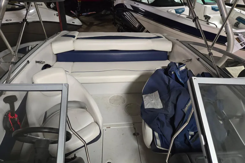 Slide: The Image of 2012 Crownline 195 SS boat interior with white and blue seating, steering wheel, and windshield. - 26