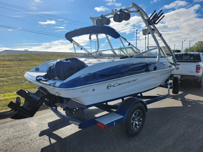 Slide: The Image of 2012 Crownline 195 SS boat on trailer, parked outdoors under a clear sky. - 3