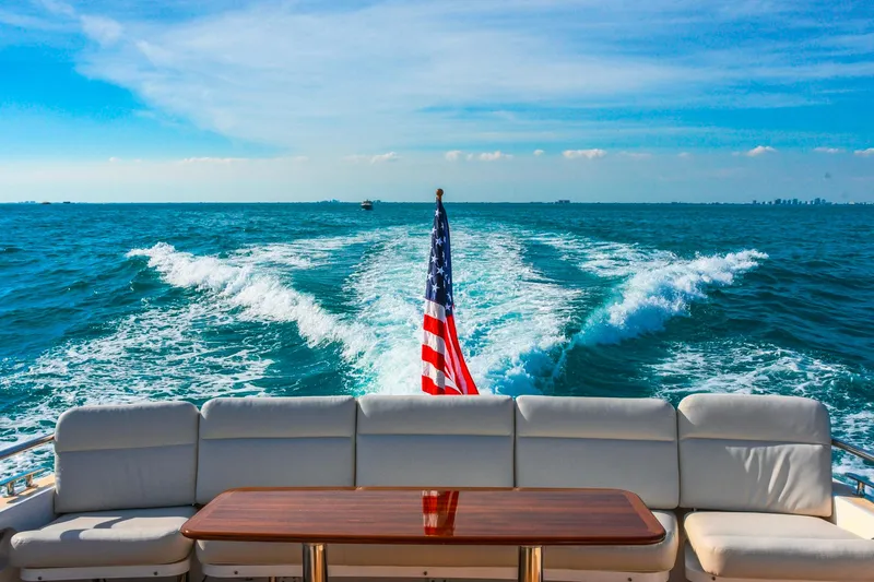 Slide: The Image of A 2018 MJM 50z yacht cruising with American flag, ocean view, and clear sky. - 11