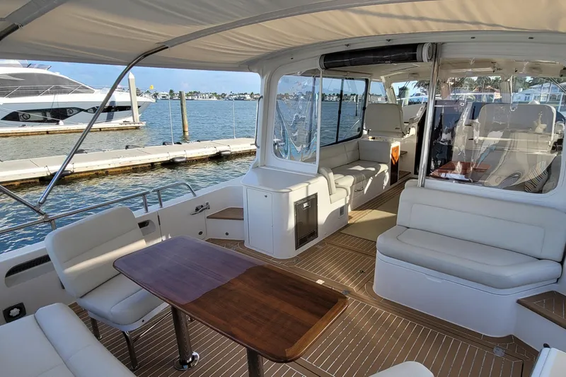 Slide: The Image of Luxurious 2018 MJM 50z yacht interior with elegant seating and wooden table, docked by the water. - 14