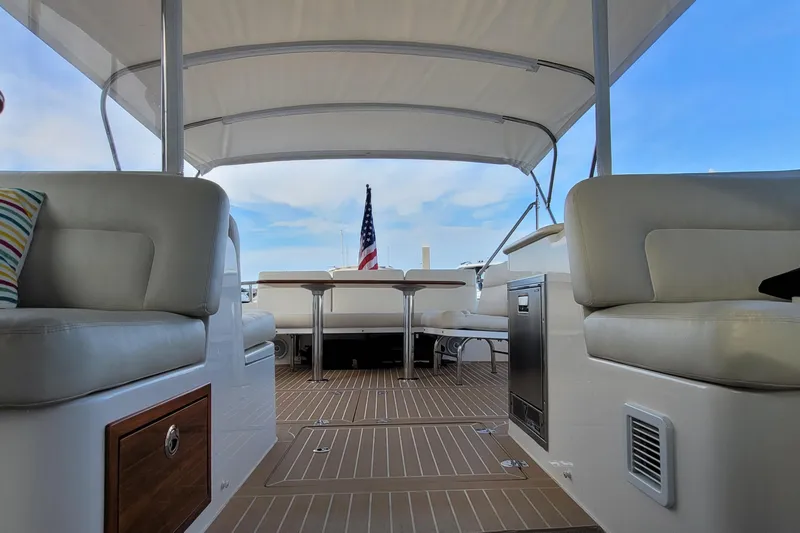 Slide: The Image of 2018 MJM 50z yacht interior with seating, table, and American flag in the background. - 39