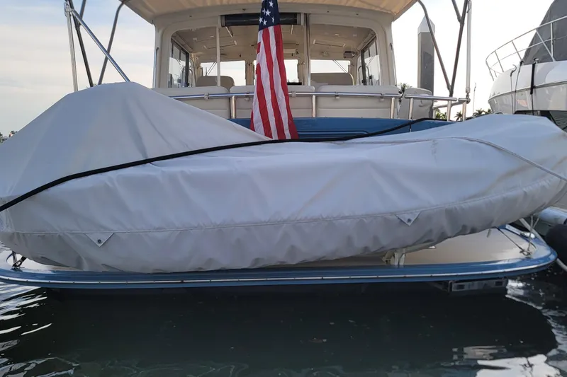 Slide: The Image of 2018 MJM 50z yacht with covered dinghy and American flag at dock. - 51
